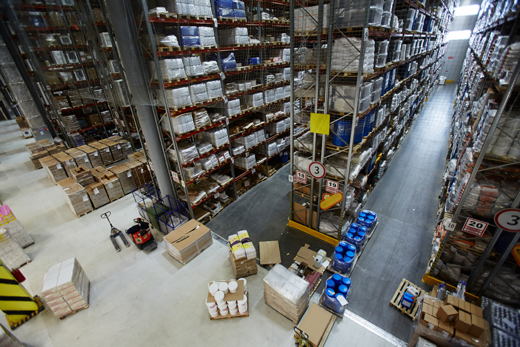 Smart warehouse with IoT-powered inventory management: High-rack storage system with pallets and goods tracked using RFID sensors and real-time IoT logistics solutions. Connected supply chain technology enhances efficiency, reduces errors, and optimizes warehouse operations.